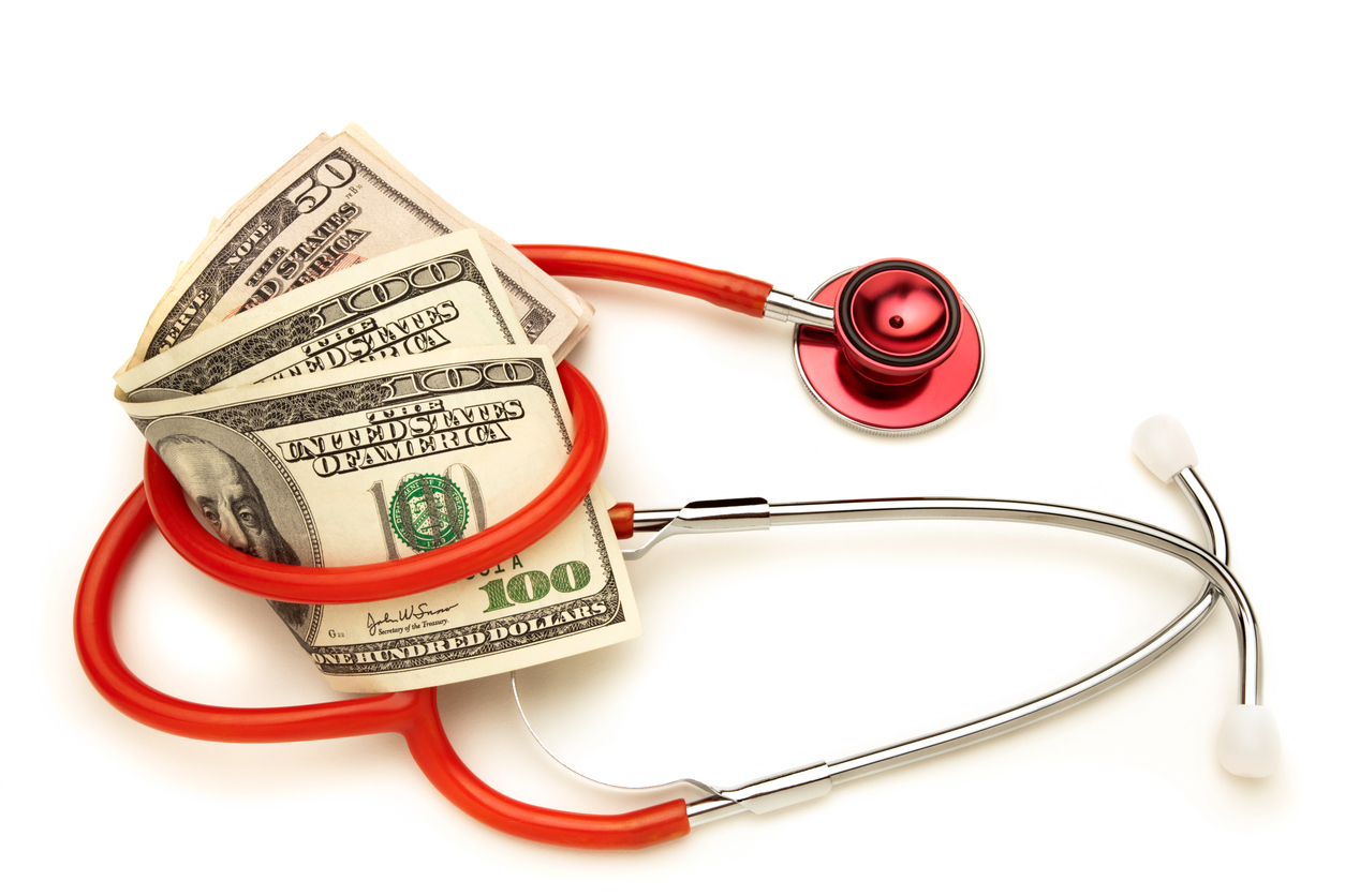 Rising Medical Costs; Red Stethoscope Wrapped Around Money, White Background
